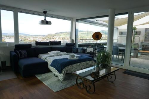 uma sala de estar com uma cama e um sofá em Switzerland Suite im 12. Stock em Thun