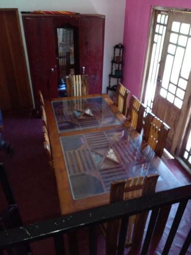 una stanza con un tavolo in legno con sedie intorno di Green View In Nuwaraeliya a Nuwara Eliya