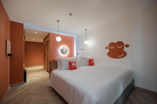 a bedroom with a large white bed with red pillows at Blu Monkey Hub and Hotel Bangsaen in Ban Bang Saen (1)