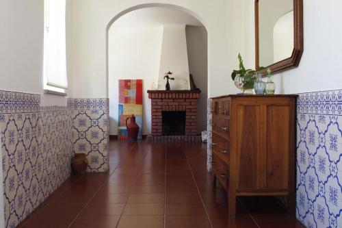 a room with a fireplace and a wooden dresser at Vivenda Costa in Tondela