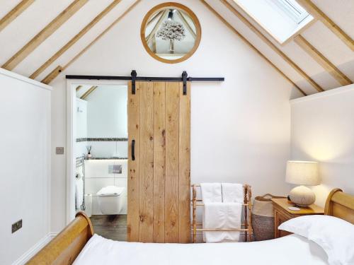 a bedroom with a wooden door and a bathroom at Walnut Studio - Horsham in Horsham