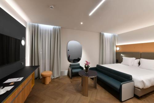 a hotel room with a bed and a television at Palazzo Tirso MGallery Cagliari in Cagliari
