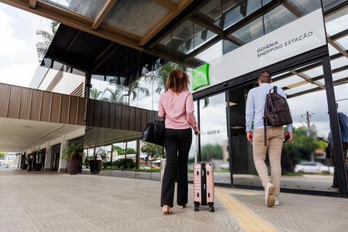 a man and a woman walking outside of a store at ibis Styles Goiânia Shopping Estação in Goiânia