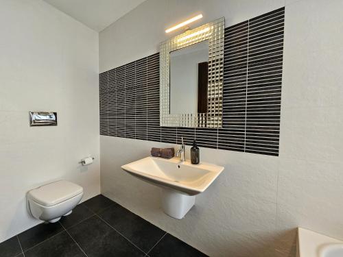 a bathroom with a sink and a toilet and a mirror at Malta Unique Penthouse Spacious Terrace-Sleeps 8 in Mġarr