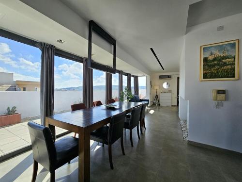 a dining room with a wooden table and chairs at Malta Unique Penthouse Spacious Terrace-Sleeps 8 in Mġarr