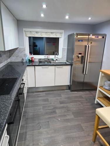 a kitchen with white cabinets and a stainless steel refrigerator at 4-Bed Lodge in flamborough Bridlington sleeps 8 in Bridlington