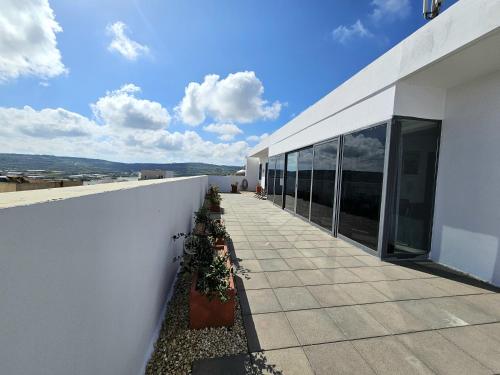 a white building with plants on the side of it at Malta Unique Penthouse Spacious Terrace-Sleeps 8 in Mġarr
