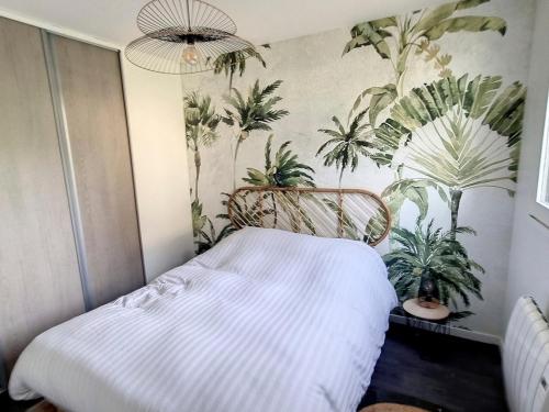 - une chambre dotée d'un lit avec des plantes sur le mur dans l'établissement Charmant Appartement avec Jardin Proche Plage et Commerces - 4 Couchages, Parking et WIFI - FR-1-746-18, à Courseulles-sur-Mer
