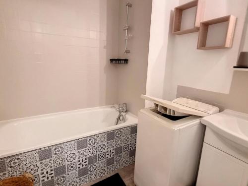 une salle de bain avec une baignoire, des toilettes et un lavabo dans l'établissement Charmant Appartement avec Jardin Proche Plage et Commerces - 4 Couchages, Parking et WIFI - FR-1-746-18, à Courseulles-sur-Mer