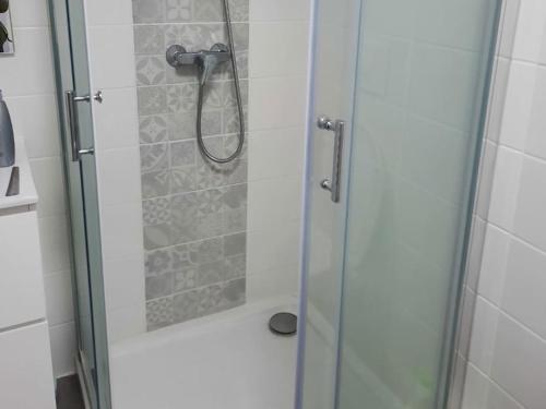 baño con ducha y puerta de cristal en Gîte LES DUNES 47C, en Bricqueville-sur-Mer