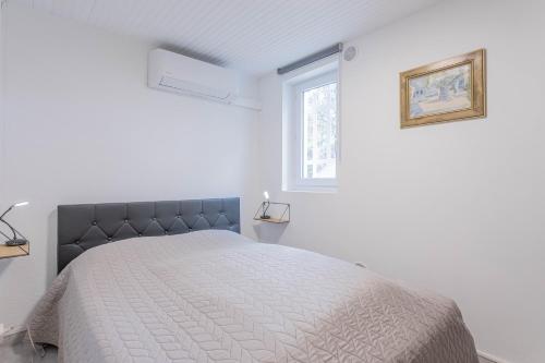 Habitación blanca con cama y ventana en Rez Villa 65m² 5 min centre plages, en Saint-Raphaël