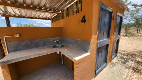 a bathroom with a sink on the side of a building at Opuwo Country Lodge Campsite in Opuwo