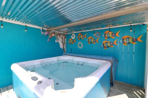 een bad in een blauwe kamer met vis aan de muur bij #1 18th Street Lower in Tybee Island