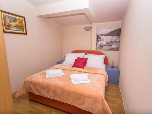a bedroom with a bed with two white and red pillows at Villa Valentina in Zadar