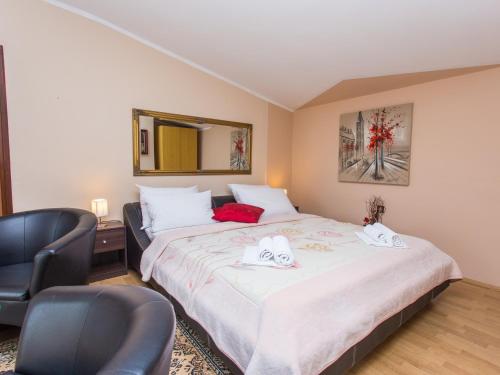 a bedroom with a large bed and two chairs at Villa Valentina in Zadar