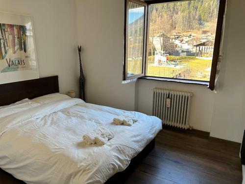 a bedroom with a bed with two towels on it at Traveller's home in the Dolomites in Porte di Rendena