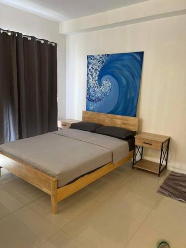 1 dormitorio con 1 cama y una pintura en la pared en Deluxe Cozy Corner Studio, en Minglanilla