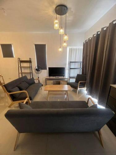 a living room with a couch and chairs and a table at Deluxe Cozy Corner Studio in Minglanilla