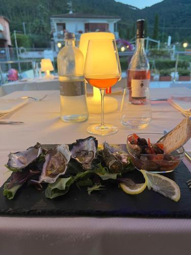 Cohete Boat في أميليا: طبق من الطعام على طاولة مع كوب من النبيذ