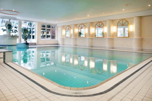 a large swimming pool in a hotel lobby at Ringhotel Hohe Wacht in Hohwacht