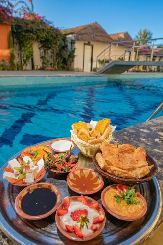a tray of food on a table next to a pool at Panorama Bungalows Resort El Gouna in Hurghada