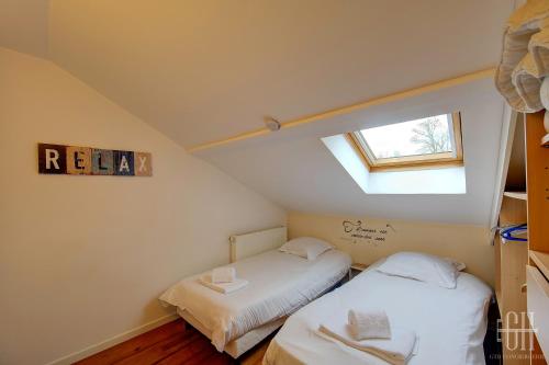 2 Betten in einem kleinen Zimmer mit Fenster in der Unterkunft HALTE 6 / Monts in Monts