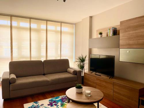 a living room with a couch and a television at Piso Vistas O Son in Cee