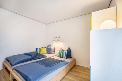 1 Schlafzimmer mit 2 Betten mit blauen und gelben Kissen in der Unterkunft Ferienwohnung Allgäuliebe in Weitnau