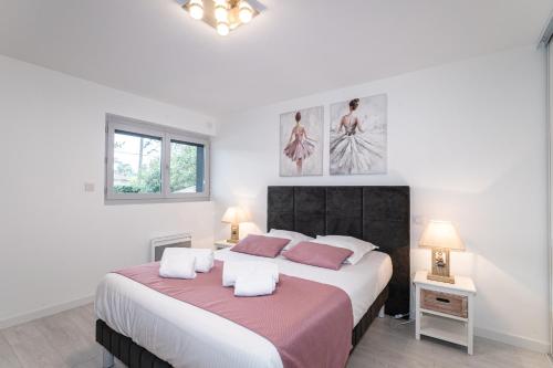 - une chambre blanche avec un grand lit et 2 oreillers dans l'établissement Face aux pins - Villa familiale piscine golf, à La Teste-de-Buch