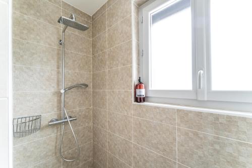 La salle de bains est pourvue d'une douche et d'une fenêtre. dans l'établissement Face aux pins - Villa familiale piscine golf, à La Teste-de-Buch