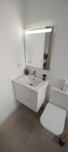 a white bathroom with a sink and a toilet at Casa Desire in Estepona