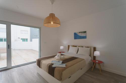 a bedroom with a bed and a pendant light at Best Houses 104 - Supertubos Beach Apartment in Atouguia da Baleia