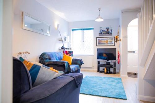 un soggiorno con 2 divani blu e un tappeto blu di Reeve House - 2-Bed - FREE Parking & Wi-Fi a Kenilworth