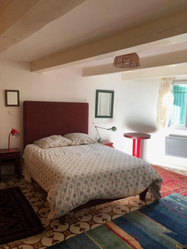 - une chambre avec un lit, une table et une fenêtre dans l'établissement Maison de village en Provence, calme et ensoleillée, à Villedieu