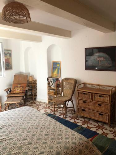 - une chambre avec un lit, une table et des chaises dans l'établissement Maison de village en Provence, calme et ensoleillée, à Villedieu