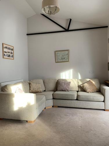 ein Wohnzimmer mit einem Sofa und einer Decke in der Unterkunft The Barn at White Rose Cottage in Towcester