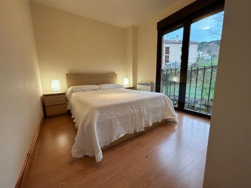 1 dormitorio con cama y ventana grande en Slowcameros El Rasillo en El Rasillo