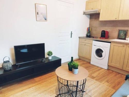 - un salon avec une table et un lave-linge dans l'établissement Nid paisible à 10 min de Disney, à Bussy-Saint-Georges
