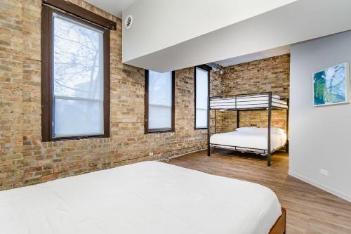 1 dormitorio con cama y pared de ladrillo en Beautifully Remodeled Flat Downtown #3N en Chicago