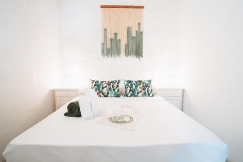 a bedroom with a bed with white sheets and pillows at Cactus Coliving in San Sebastián de la Gomera