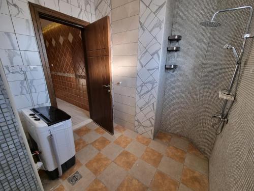 La salle de bains est pourvue d'une douche et d'une poubelle. dans l'établissement شقق الراحه, à Al Muzāḩimīyah