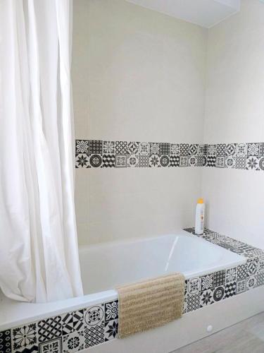 a bathroom with a bath tub with a shower curtain at Amplio y céntrico apartamento en Avilés by beBalmy in Avilés