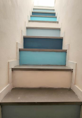 a stairwell with blue and white stairs and a window at ca' di su in Riomaggiore