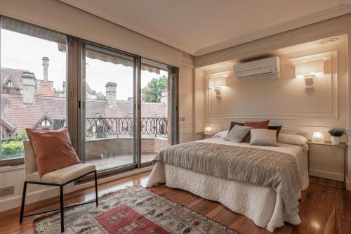 a bedroom with a bed and a large window at Miraconcha 47 in Donostia-San Sebastián