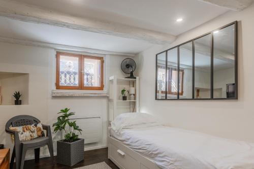 Un dormitorio con una cama y un espejo en la pared. en Appart en plein centre de Fréjus, en Fréjus