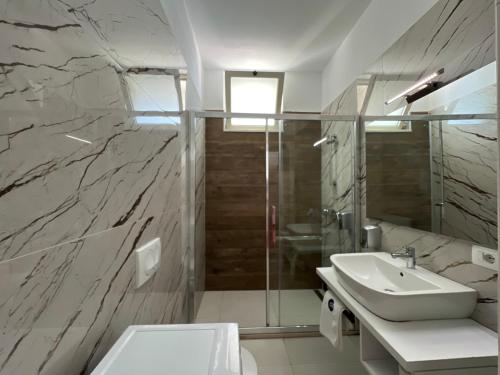 y baño con lavabo, ducha y aseo. en Apart Hotel Perla Resort Lalez Durres en Durrës