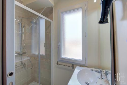 een badkamer met een wastafel, een douche en een raam bij Le Valois / Vue Sur Château D'Amboise in Amboise