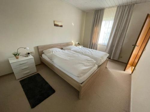 um quarto com uma cama branca e uma janela em Ferienwohnung Kiebitzheide em Beelen