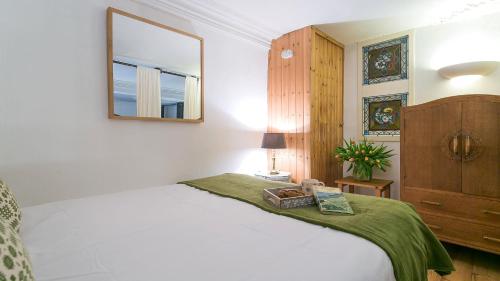 - une chambre avec un lit avec un miroir et une commode dans l'établissement Capel Bach, à Llanystumdwy