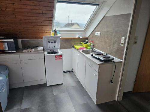 a small kitchen with white cabinets and a window at Ferienwohnung im Besigheim in Besigheim